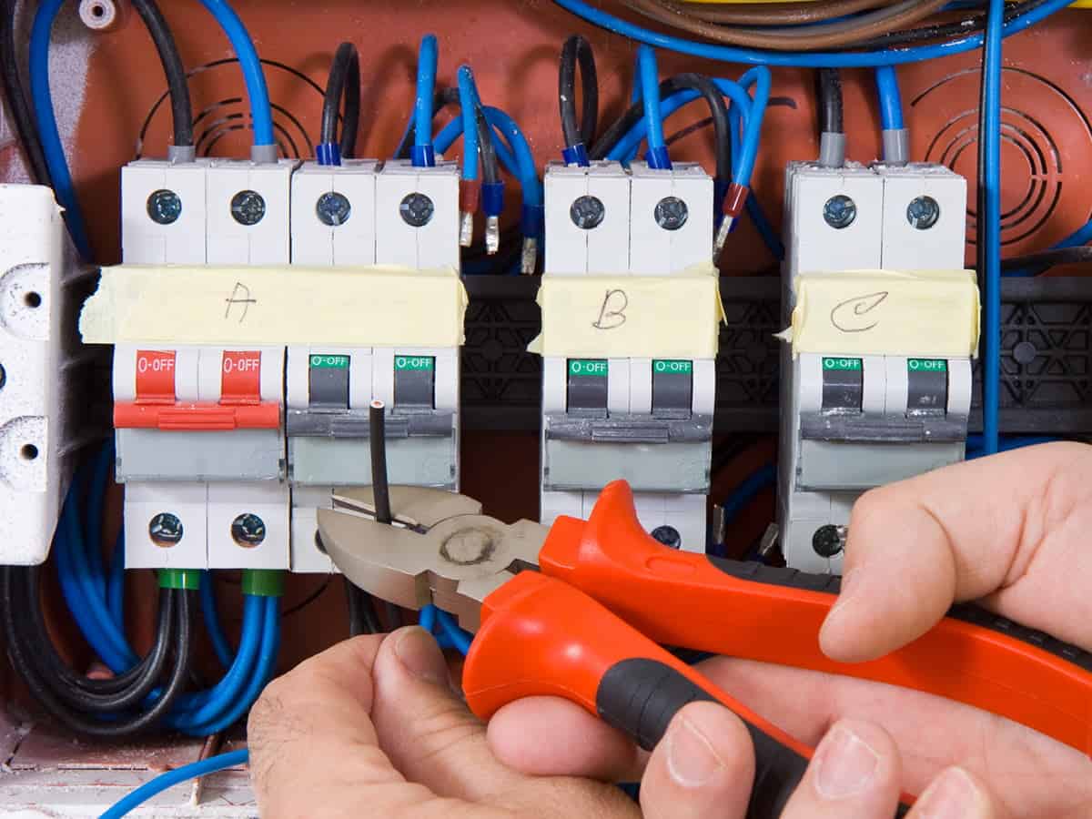 Someone clipping wires with wire cutters Someone clipping wires with wire cutters